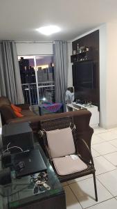 Una sala de estar con un sofá y una mesa con una computadora portátil. en Condomínio Gran Felicita Castelo, en Belo Horizonte