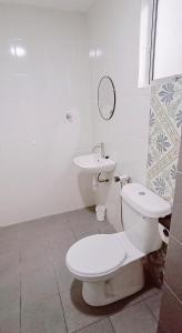 a white bathroom with a toilet and a sink at Ipoh Homestay at Anderson - 2 Room 2 Bathroom -Maximum 6 pax --Self Check In-- in Ipoh
