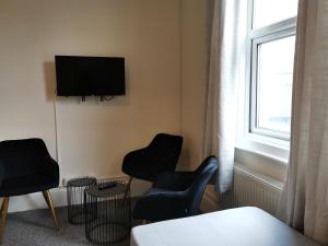 a living room with two chairs and a flat screen tv at Ax 1 Bed and Breakfast in London