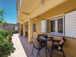 a patio with a table and chairs and a window at Charming One Bedroom Apartment Povljana - One Bedroom Apartment in Povljana
