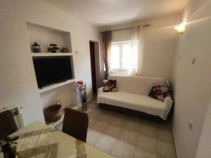 a living room with a white couch and a television at Charming One Bedroom Apartment Povljana - One Bedroom Apartment in Povljana