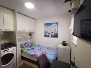 a small bedroom with a bed and a washing machine at Sea View Holiday Home Umag - Three Bedroom Holiday Home in Umag