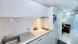 a white kitchen with a sink and a microwave at Route 66 Motor Inn in Emerald