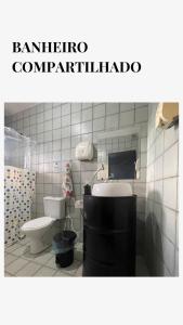 a bathroom with a toilet and a sink at Garden Room Comfort in Garanhuns