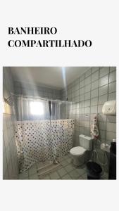 a bathroom with a toilet and a shower curtain at Garden Room Comfort in Garanhuns +9 photos