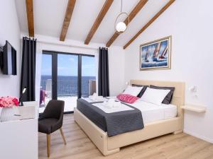 a bedroom with a bed and a table and a chair at Sunlit Shores Beach Villa with Pool, Gym and Sauna - Three Bedroom Villa with Pool in Jelsa +52 photos