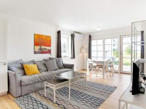 a living room with a couch and a table at Modern Holiday Haven in Læsø in Læsø