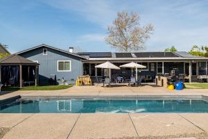 a house with a swimming pool in front of a house at Memorable Moment at Placid Blue with Pool & Hot Tub in Sacramento