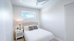 a white bedroom with a bed and a window at Modern Luxury 2bed by 7 Mile Beach in Upper Land +28 photos