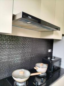two bowls on top of a stove in a kitchen at Hana Villa Hatyai in Suen Phra