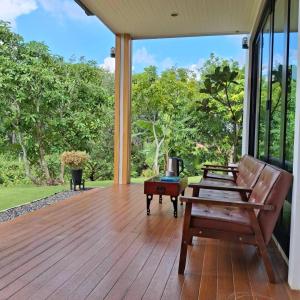 an empty porch with a bench and a table at Hana Villa Hatyai in Suen Phra