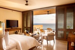une chambre avec un lit et une vue sur l'océan dans l'établissement Four Seasons Resort Tamarindo, México, à Cihuatlán