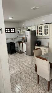 a kitchen with a refrigerator and a table at Casa com piscina e área gourmet para o São João in Campina Grande