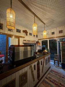 a kitchen with a counter with a television and lights at Riccio Guest House & Cafe in Nusa Lembongan