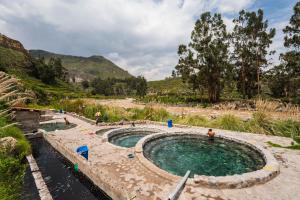 a pool of water with people standing around it at Colca Casa Las Flores in Coporaque