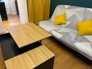 a couch and two tables in a living room at Studio central et chaleureux in Belley
