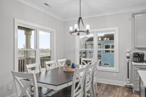 a kitchen and dining room with a table and chairs at Forever Blue home in Pine Knoll Shores