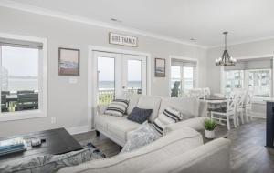 a living room with a couch and a table at Forever Blue home in Pine Knoll Shores +51 photos