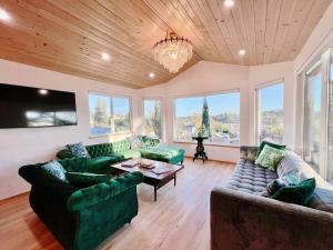 a living room with green couches and a tv at The Perch- Hilltop Bungalow, Eagle Rock-near DTLA in Los Angeles