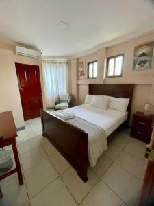 Un dormitorio con una cama grande y una silla. en Hotel Terraza Zoe, en Managua