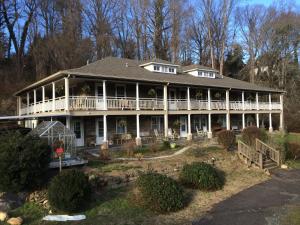 a large white house with a large porch at Calhoun House Inn & Suites in Bryson City