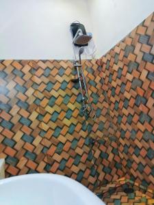 a bathroom with a toilet and a wooden floor at Nine arch home stay in Nikawatawana