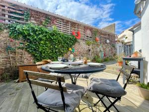 a patio with a table and chairs on a deck at Maison rénovée, loft artiste, Brem Sur Mer, 3 pers, WIFI - FR-1-231-336 in Brétignolles-sur-Mer
