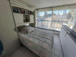 a small bedroom with a bed and a window at Villa T3 Mitoyenne Climatisée avec Piscine et Parking, Cap d'Agde - FR-1-607-217 in Cap d'Agde +20 photos