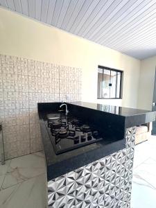 eine Küche mit einer schwarzen Theke und einem Herd in der Unterkunft Casa Davisis - Parada Jalapão e Próximo Aeroporto in Palmas + 9 Fotos