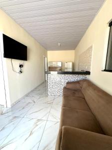ein Wohnzimmer mit Sofa und Fernseher in der Unterkunft Casa Davisis - Parada Jalapão e Próximo Aeroporto in Palmas