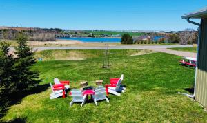 a group of chairs and a table in the grass at Niseko Riverside By Zen Life 4Bedrooms Greenie Cottage and 3bedrooms Cowie Cottage in New Glasgow