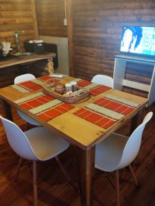 a wooden table with white chairs and a table with at Cabañas Olavarría 2 in La Porteña
