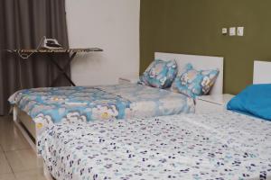 a bedroom with two beds with blue comforter at Chic appartement à la Riviera Palmeraie in Abidjan