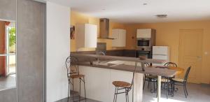 a kitchen with a counter and stools in it at Maison entière garage à 5 minute à pied des grands buffets et centre ville in Narbonne