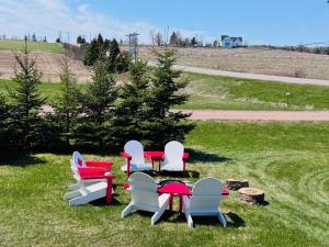 a group of chairs and a table in the grass at Niseko Riverside By Zen Life 4Bedrooms Greenie Cottage and 3bedrooms Cowie Cottage in New Glasgow
