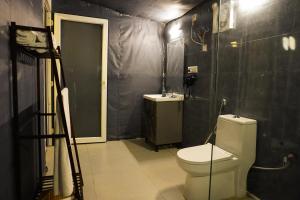 a bathroom with a toilet and a sink at Buransh Luxury Tent Retreat in Majkhali in Chaubattia