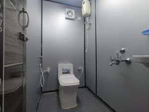a small bathroom with a toilet and a shower at Hallimane Homestay in Udupi