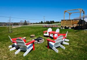 a group of red and white chairs sitting in the grass at Niseko Riverside By Zen Life 4Bedrooms Greenie Cottage and 3bedrooms Cowie Cottage in New Glasgow +75 photos
