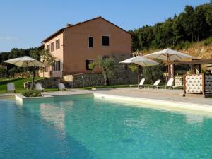 a swimming pool with chairs and umbrellas next to a building at Farmhouse in Montoro near Montoro Castle in Narni