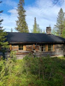 an old log cabin with a black roof at Villa Karhunkehto in Luosto