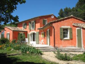 una casa in mattoni rossi con un giardino di fronte di B&B La Cigaline a Vaison-la-Romaine