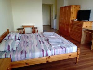 a bedroom with a bed and a tv and a desk at Guest House Diamant in Sozopol