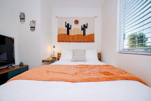 a bedroom with a bed and a flat screen tv at Cactus Cottage in Yuma