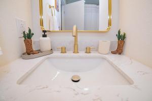 a bathroom with a white sink with a mirror at Cactus Cottage in Yuma