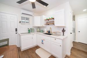 a kitchen with white cabinets and a ceiling fan at Cactus Cottage in Yuma +3 photos