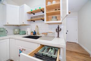 a kitchen with white cabinets and a sink at Cactus Cottage in Yuma