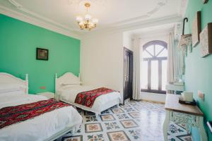 a bedroom with two beds and a chandelier at 一千零一夜喀什古城民宿 Kashgar Ancient City Scenic Area in Kashgar