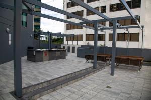 a patio with two benches and a table on a building at Private CBD Bedroom in a Shared Apartment on Brisbane River in Brisbane