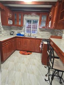 a kitchen with wooden cabinets and a pizza on the floor at Historic Manor in Bridgetown