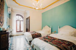 a bedroom with two beds and a chandelier at 一千零一夜喀什古城民宿 Kashgar Ancient City Scenic Area in Kashgar